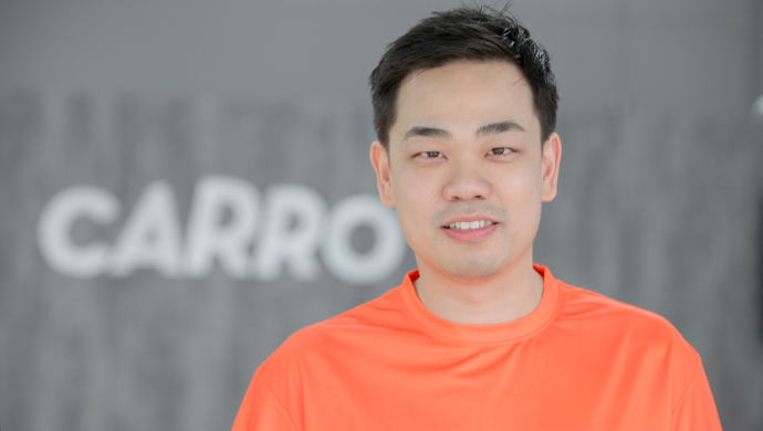 Carro CEO, Aaron Tan in front of a Carro logo